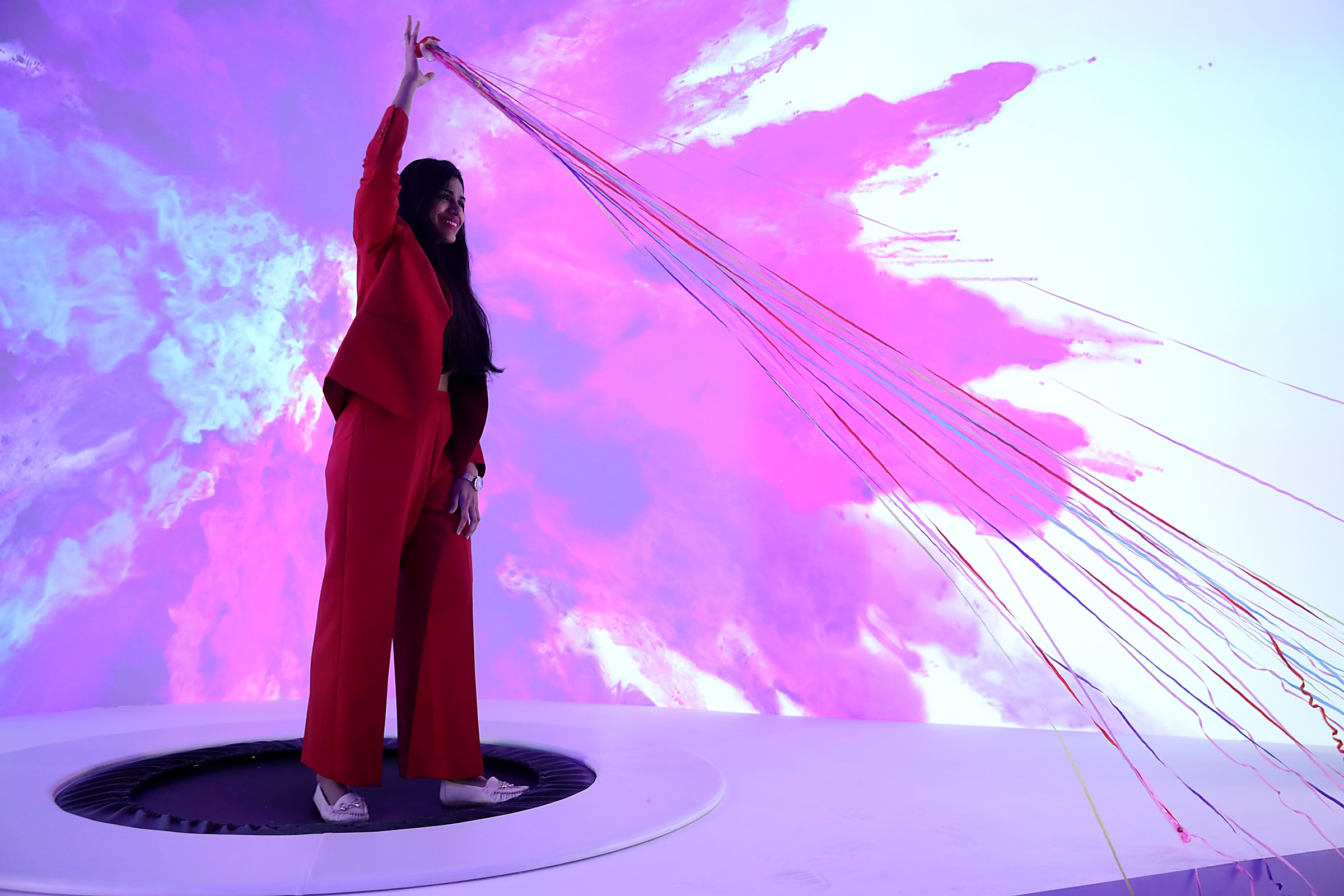 A creator on the trampoline, streamers against the projection