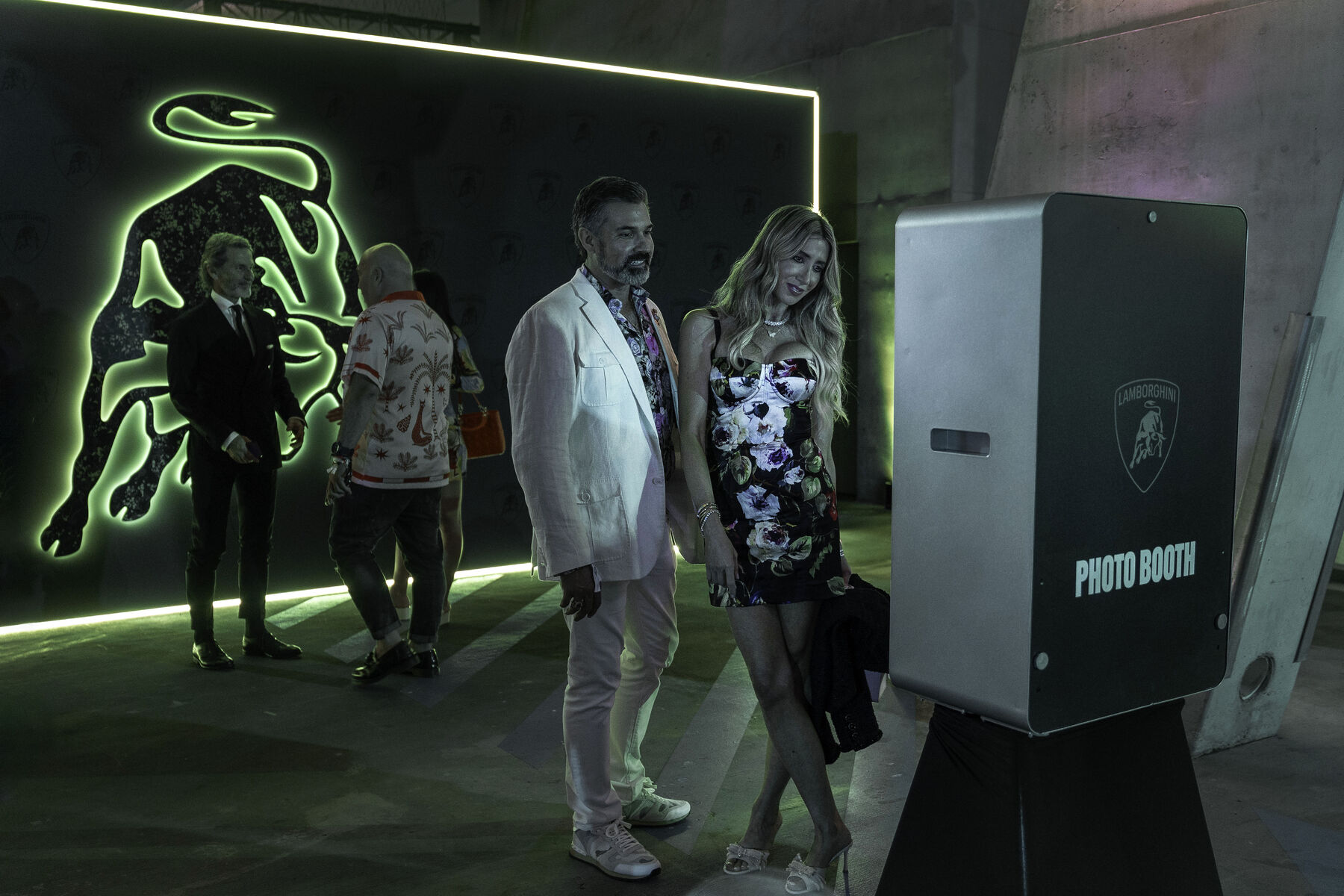 Guests beside the neon bull wall and photo booth
