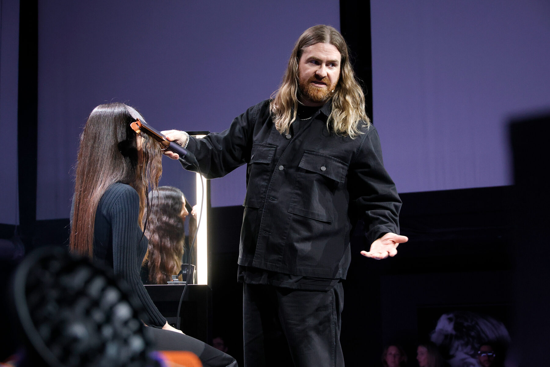 A stylist demonstrating the Airstrait on stage