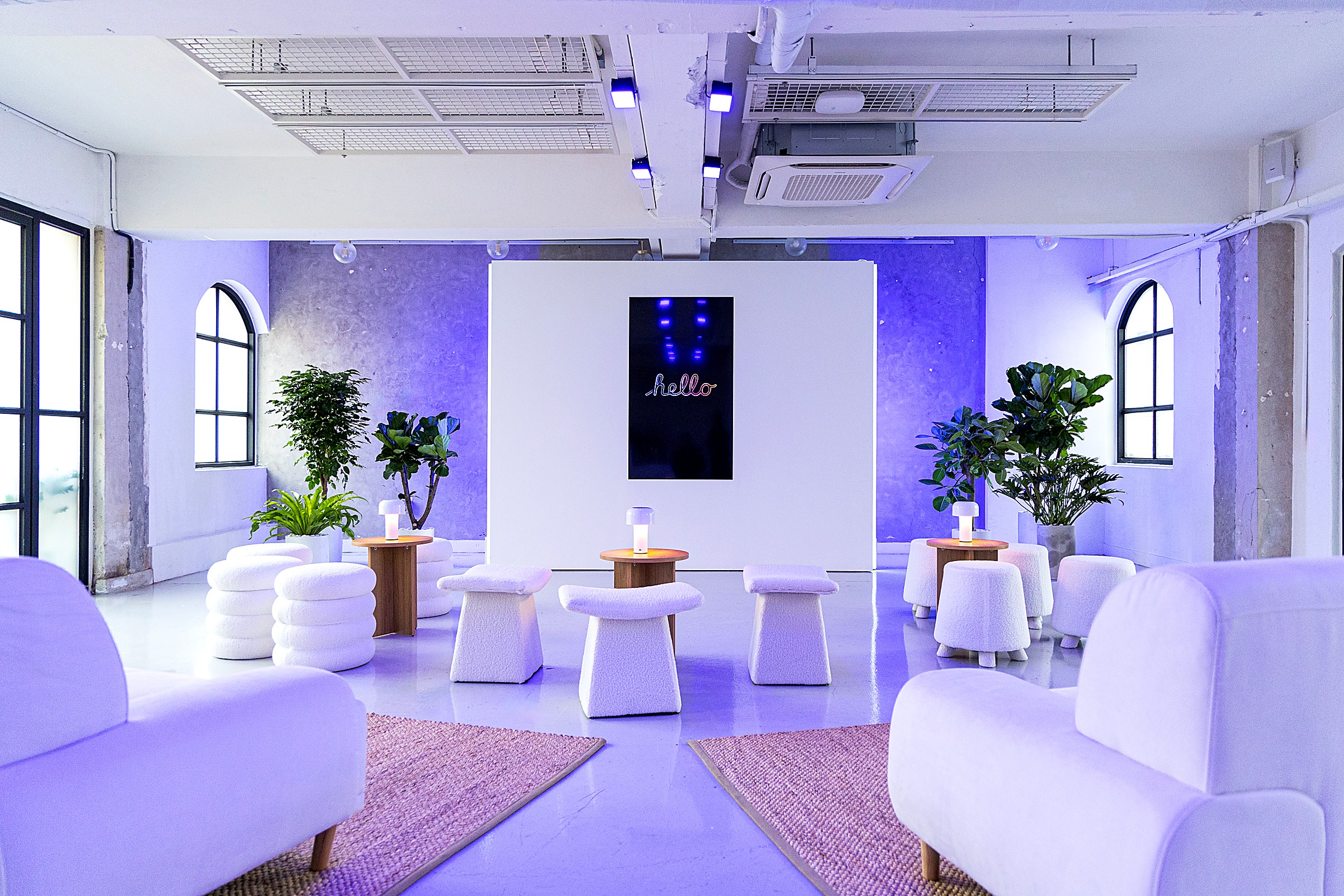 The welcome lounge, with a neon “hello” screen and soft seating