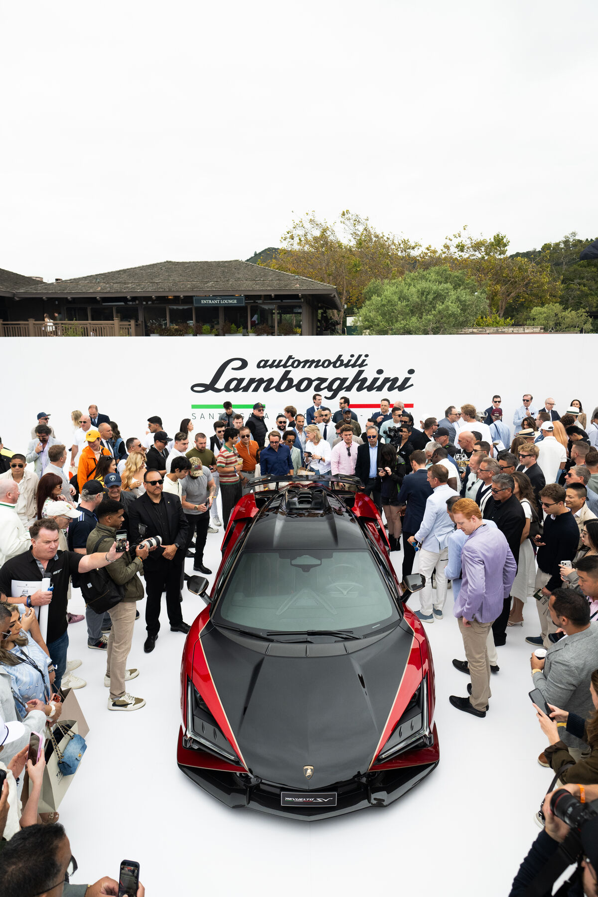 Guests photographing a Lamborghini reveal on the display stage at Monterey Car Week