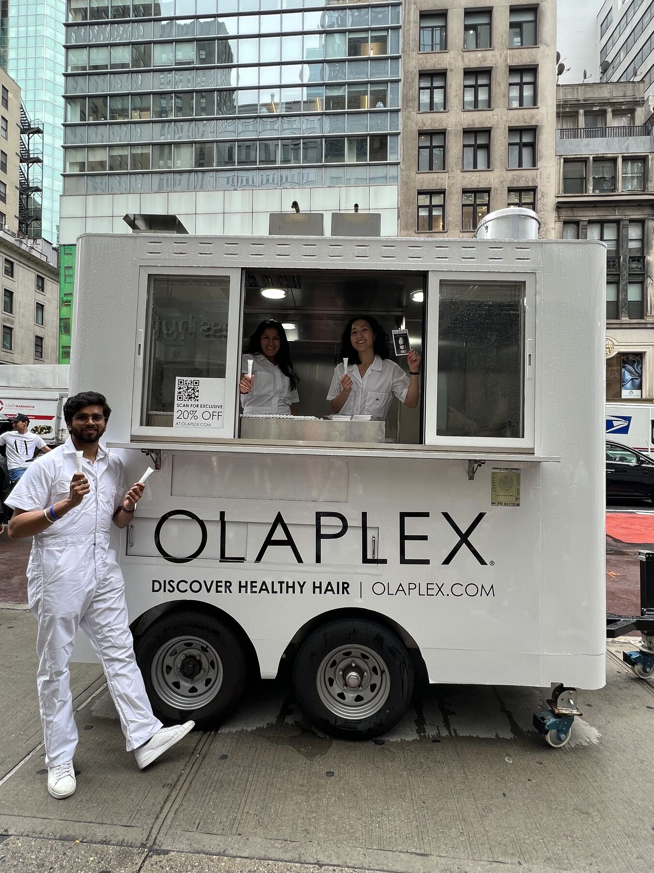 The branded Olaplex sampling trailer and field team on a city street