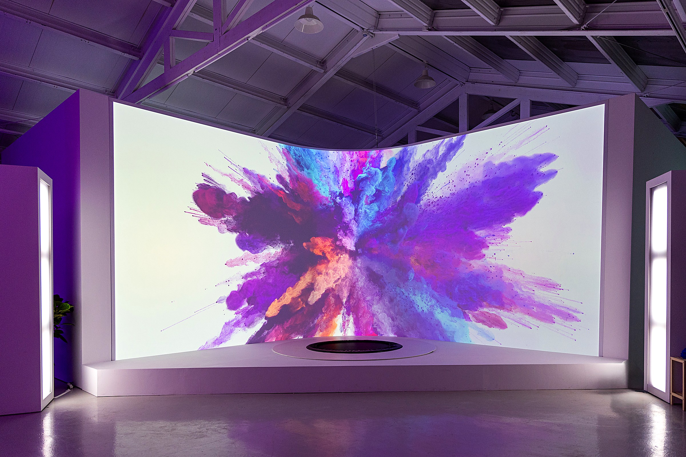A trampoline set in front of a curved 3D projection wall