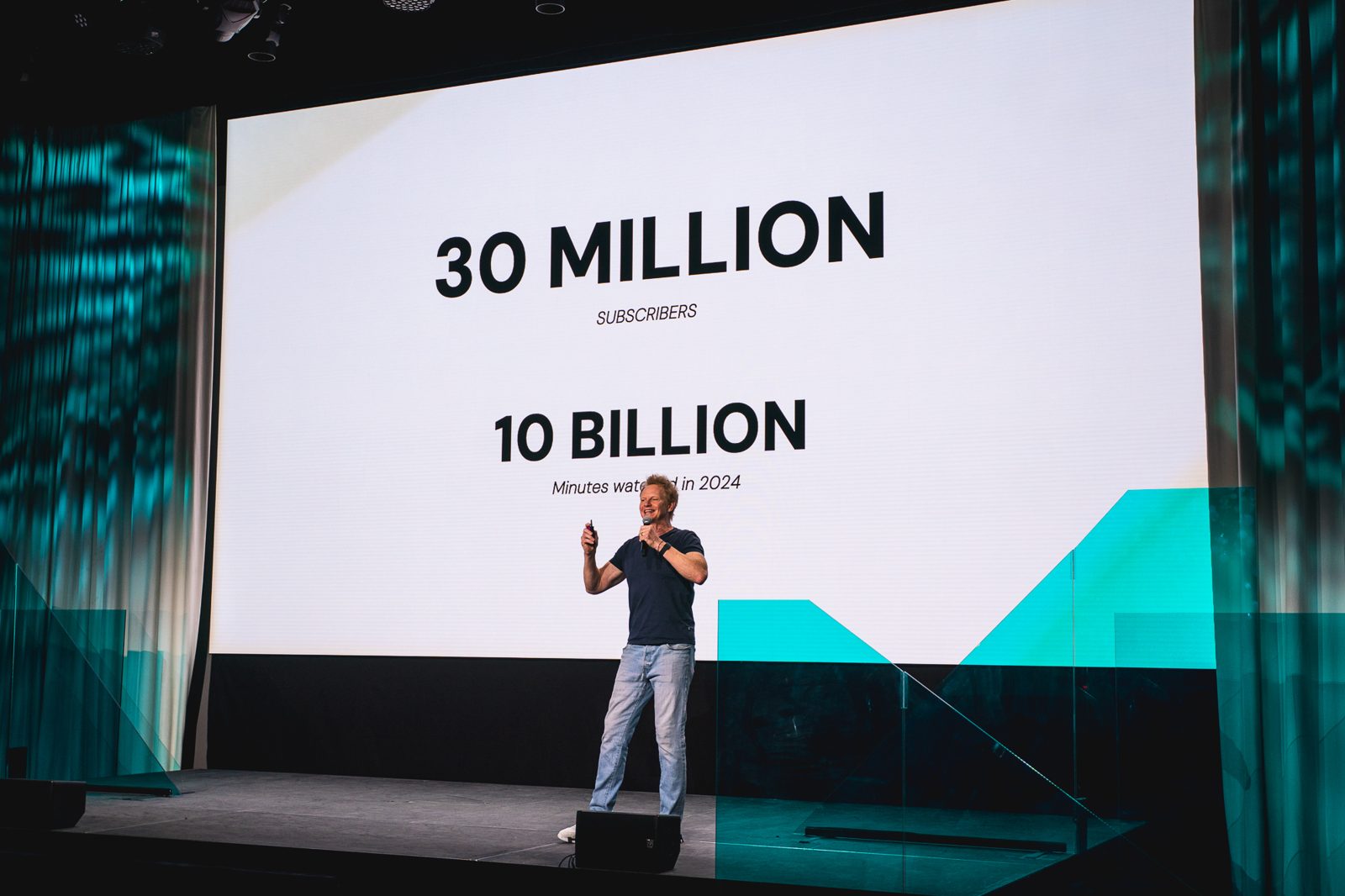 A keynote on stage showing creator audience figures
