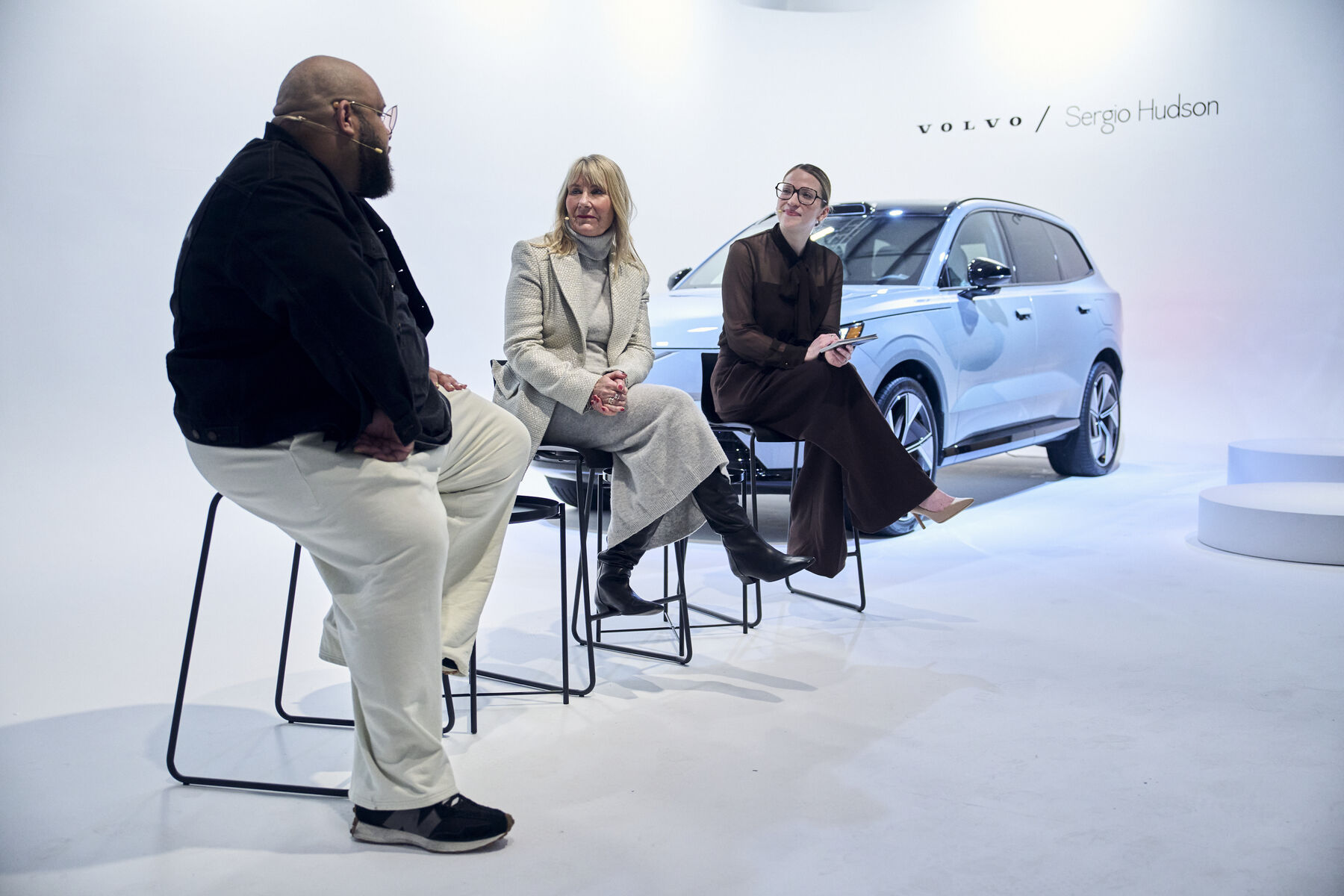Sergio Hudson and hosts in conversation beside the EX90 on the studio set